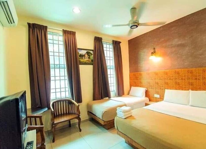 Hotel Seri Nilai guest room with twin beds, window chairs, and ceiling fan in Kampung Baharu Nilai
