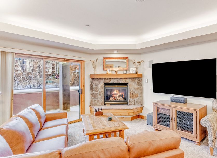 Canyon Creek, Steamboat Springs living room with fireplace, TV, sofa and balcony door