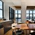 Wythe Hotel in Brooklyn with a bright loft-style lounge, round table, and skyline-view windows.