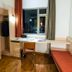 ibis Saigon South room with desk, chair, open wardrobe and city view in Ho Chi Minh City