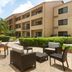 Courtyard by Marriott Fort Myers Cape Coral patio seating with palm trees and hotel exterior