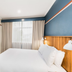 Statesman Hotel Canberra room with king bed, wall-mounted TV, and window with curtains