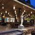 Wild Orchid Villa Krabi in Krabi: open-air restaurant with hanging lanterns and a white statue at dusk
