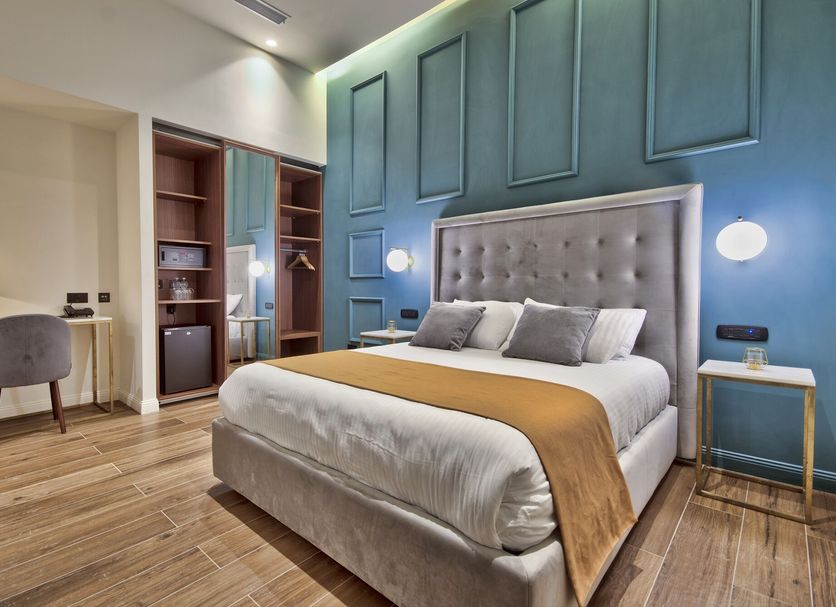 23 Boutique Hotel in Floriana room with tufted bed, blue paneled wall, wood floor and desk