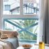 Résidence Pierre & Vacances Premium Haguna room with sofa, window seat, and sea-view palm trees in Biarritz