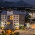 Courtyard by Marriott San Salvador hotel exterior at night with illuminated entrance and mountain backdrop