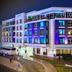 TIME Grand Plaza Hotel in Dubai at night with blue and purple-lit exterior and curved driveway