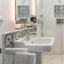 Hotel Tayko Sevilla bathroom with marble shower, pedestal sink and patterned tile accents in Seville