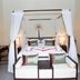Yushuigu Hot Spring Hotel in Maoming, four-poster bed with white canopy curtains and bedside lamps