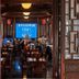 Changle Inn in Yangzhou dining room with wooden tables, lanterns and a blue-lit stage