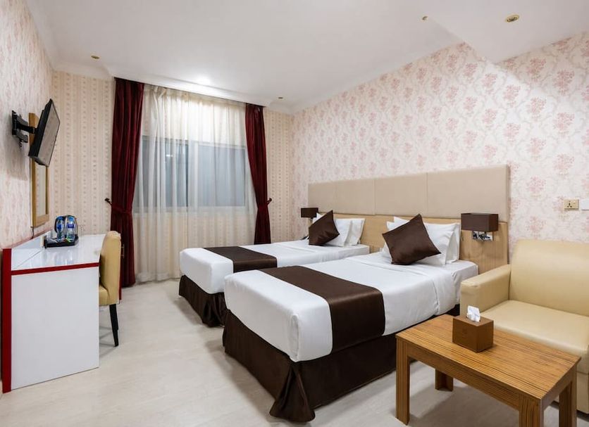 Royal Tulip Hotel Llc Dubai guest room with two twin beds, desk, sofa, and window with curtains
