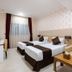 Royal Tulip Hotel Llc Dubai guest room with two twin beds, desk, sofa, and window with curtains