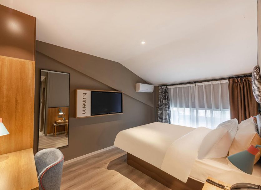 Home Inn Suzhou Mudu Ancient Town Lingyanshan Metro Station room with bed, desk and wall-mounted TV in Suzhou