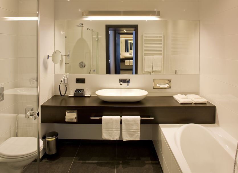 Van Der Valk Hotel Brugge Oostkamp bathroom with soaking tub, walk-in shower and modern vanity in Oostkamp