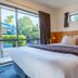 Tasman Holiday Parks - Coromandel room with queen bed, wood-paneled wall and garden view through large window