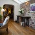 Tudor Farmhouse in Coleford with rustic stone wall, skylight, wicker chairs and wooden floor