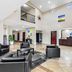 Days Inn by Wyndham Rockdale Texas lobby with black chairs, front desk, high ceiling and upper balcony