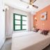 La Venecia de Canarias Puerto de Mogan room with coral accent wall and twin bed in Mogán