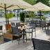 Outdoor terrace seating at Hotel Asgard in Gersthofen with umbrellas and tables by the entrance.
