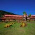 Frangipani Hotel Boutique in Brotas with red-roofed buildings and a landscaped green lawn