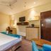 The Platinum Hotel Hyderabad room with bed, desk, wall-mounted TV, and small kitchenette