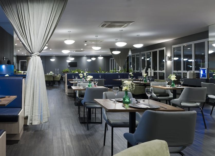 Comfort Suites Flamboyant, Goiânia: modern hotel dining area with tables, chairs and large windows