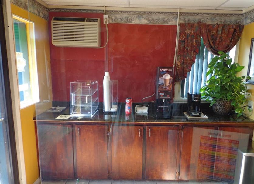 Economy Inn Express Warren lobby coffee station with beverage dispenser, microwave, plant and mini fridge