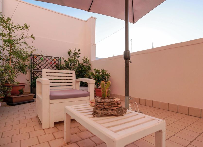 Bed and Breakfast Cairoli in San Pietro Vernotico rooftop terrace with seating, umbrella and potted plants