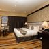 Al Muhaidb Residence Al Ahsa in Hofuf guest room with king bed, desk, TV and patterned carpet