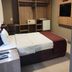 Esplanada Brasilia Hotel room with bed, built-in wardrobe, desk, and wall-mounted TV in Brasilia