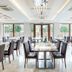 Rozany Gaj Gdynia dining room with set tables, dark chairs and large windows overlooking greenery