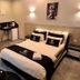 Spat Hotel Ashdod room with double bed, bathroom sink area, and wall portrait in Ashdod