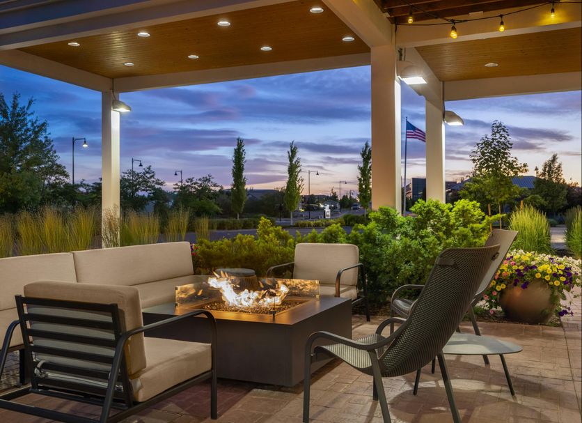 Home2 Suites by Hilton Idaho Falls outdoor patio with fire pit and seating at dusk