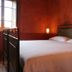 Agriturismo Podere Pratovecchio in Montefollonico bedroom with wrought-iron bed and red walls