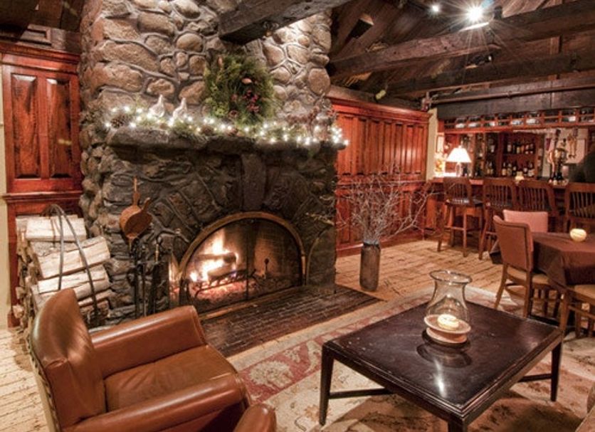 Cozy stone fireplace lounge at York Harbor Inn in York Harbor with leather chairs and wood beams