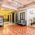Hotel NavaRATNA in Coimbatore lobby with seating, potted plants and tiled floor