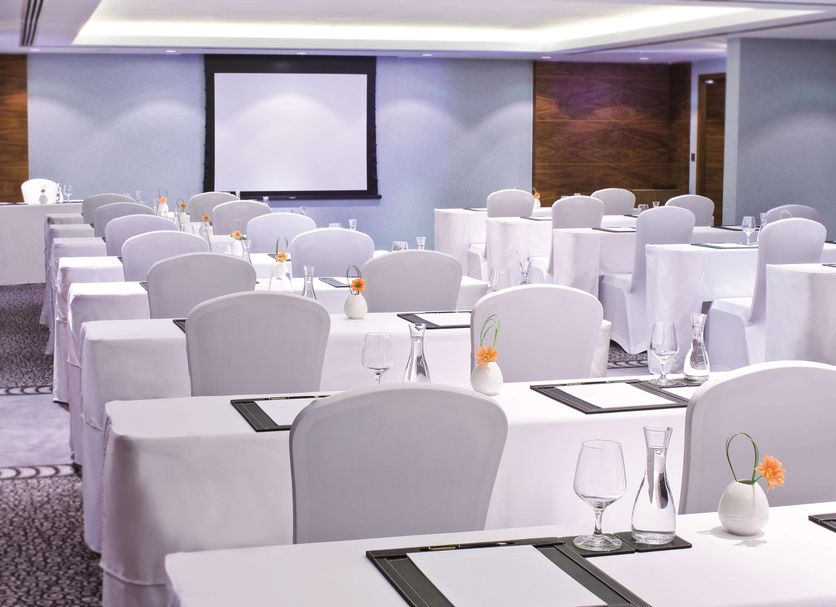 Avani Deira Dubai Hotel meeting room in Dubai with rows of white-clothed tables and chairs