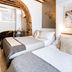 LE 5 Terre LA Spezia guest room with two white beds, brick arch, and abstract wall art in La Spezia