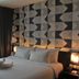Luminor Hotel Jemursari by Wh, Surabaya guest room with patterned accent wall and bed near window