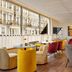 The Cura Hotel Kensington, London breakfast lounge with colorful seating and street-facing windows