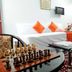Blooming Paradise, Thekkady room with chess table, twin beds and orange accents