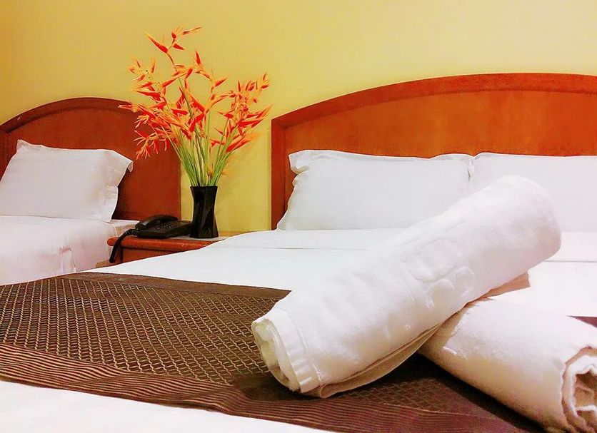 Global Hotel Labuan room with two beds, white linens and folded towels in Labuan