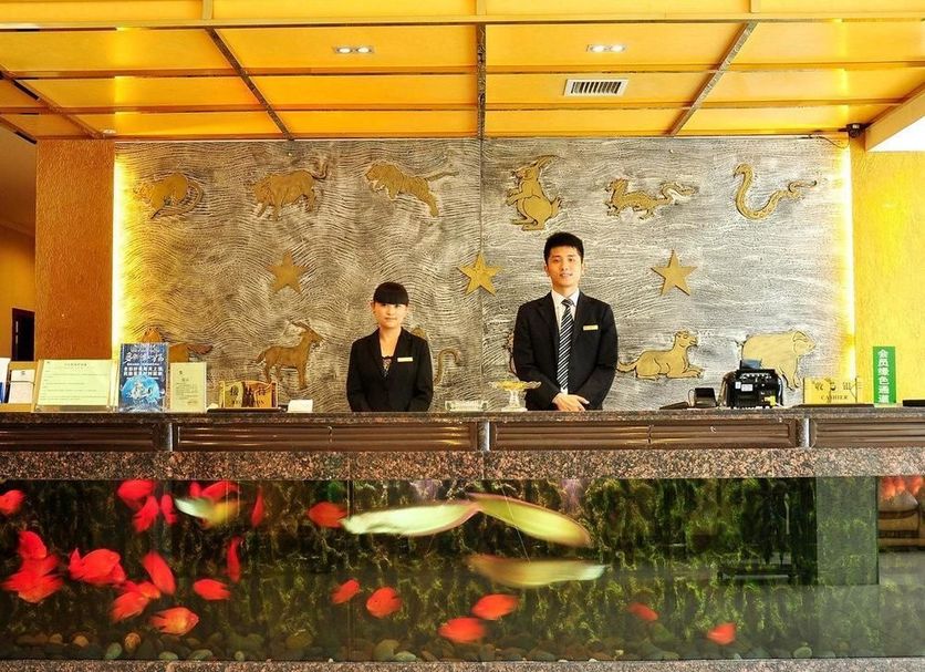 Nan Xiang Hotel - Guiyang front desk with two staff and illuminated fish tank reception counter