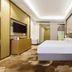 Fulai Garden Hotel Shenzhen guest room with bed, wall-mounted TV, and floral wall art