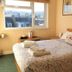 Avoncourt Lodge, Ilfracombe guest room with double bed, floral bedding, and window view over rooftops.