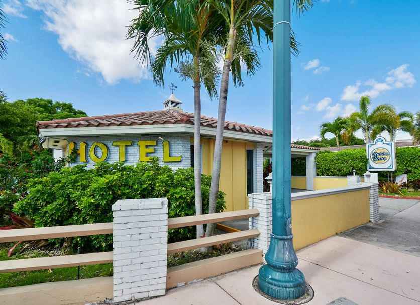 OYO Hotel Coral Gables - Miami Airport exterior in Coral Gables with palm trees and roadside sign