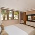 Kenzi Rissani hotel room in Errachidia with palm-tree view, sitting area, and wood-accent partition