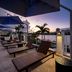 Hilton Garden Inn San Juan Condado rooftop terrace with lounge chairs, umbrellas and sunset city views