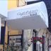 Gythion Hotel in Gytheio with outdoor café seating and hanging pink flowers at the entrance