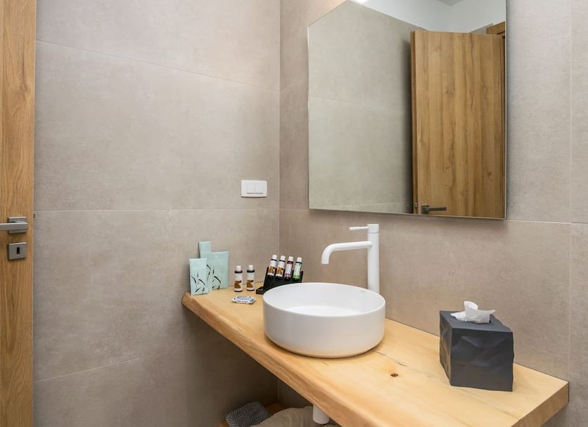 Olive Studios Adamantas bathroom vanity with vessel sink, mirror, toiletries and tissue box